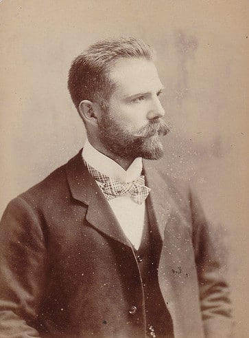 Vintage portrait man in suit with bowtie full beard mustache.