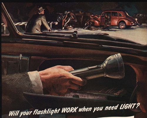 Vintage man sitting in the car and holding flashlight in his hand.