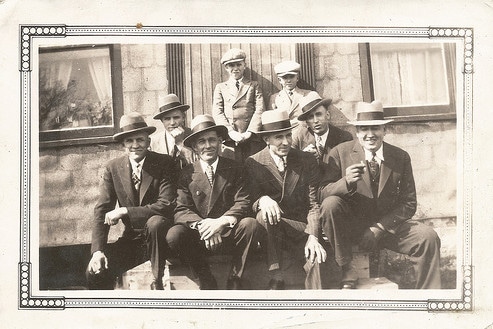 Vintage group of men friends posing for photo cigars suits fedoras.