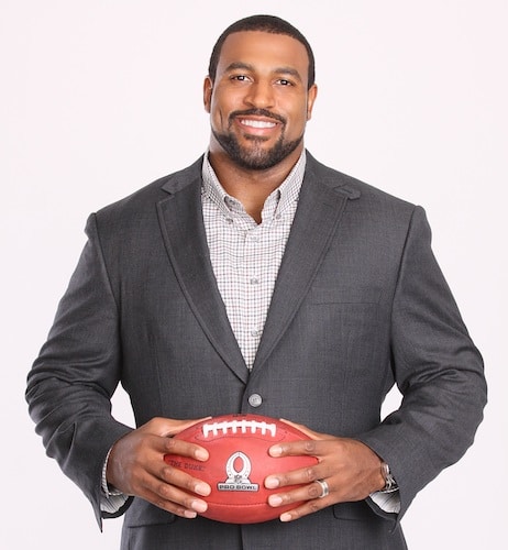 Duane brown houston texans wearing suit holding football.