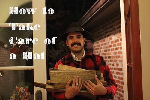 Man in red flannel with firewood wearing fedora.