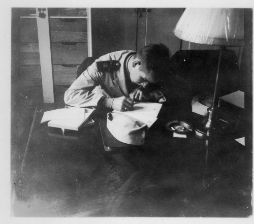 Vintage military soldier writing letter at desk.