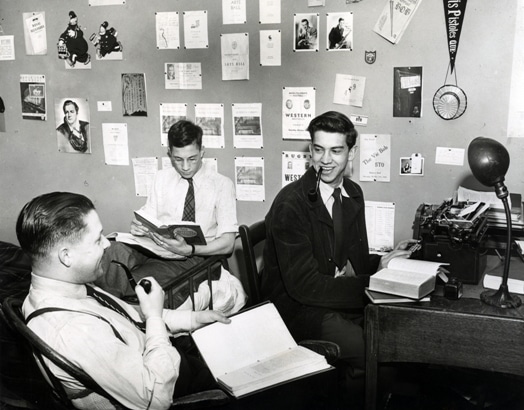 Vintage victoria university students in their dorms rooms smoking pipes studying.