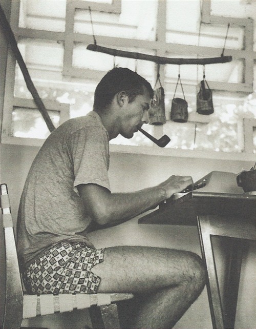 Hunter's Thompson in boxers underwear writing on typewriter smoking pipe.