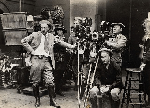 Vintage early 1900s film director with huge cameras on set.