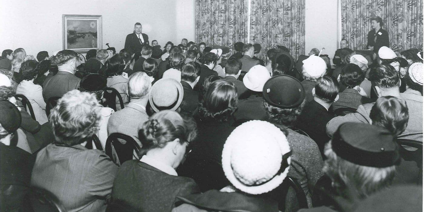 Vintage gathering conference back of people's heads.