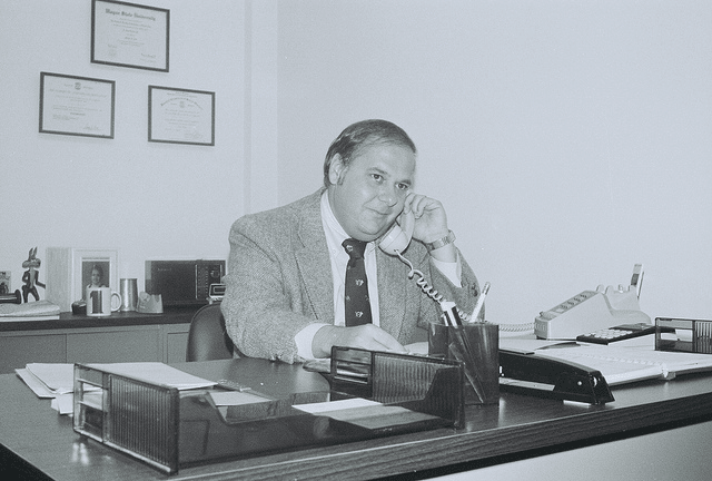 Vintage businessman at desk in suit talking on phone 