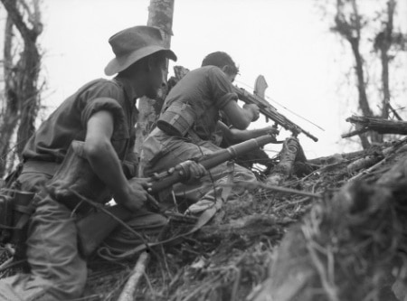 Vintage soldiers charging climbing up hill with rifles.