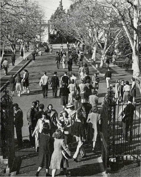 Vintage college campus students walking in and out of front gate.