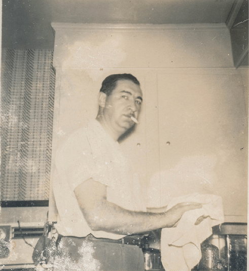 Vintage man it kitchen drying dishes smoking cigarette.