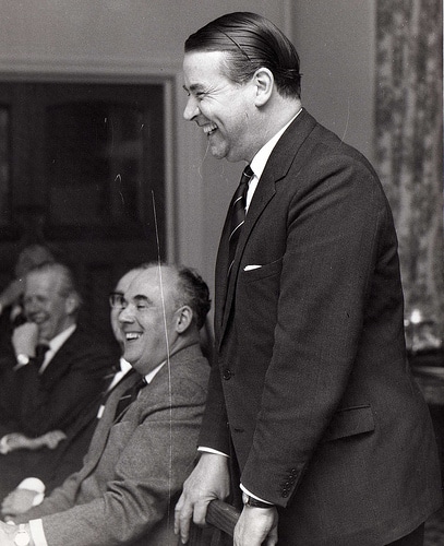 Vintage man standing at meeting smiling laughing.