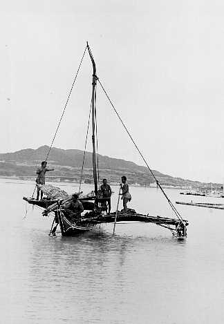 trukese native indian men on sailboat in water