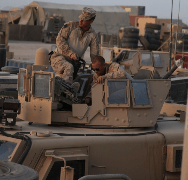 Soldier sitting on a hummer army truck.
