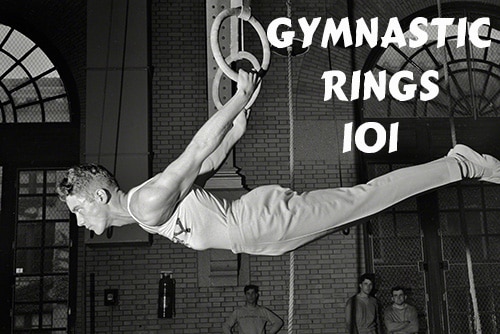Vintage gymnast hanging on gymnastic rings.