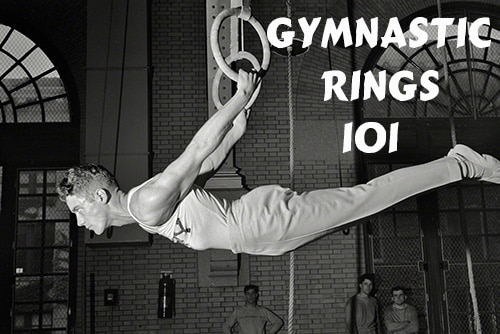 Vintage gymnast hanging on gymnastic rings. 