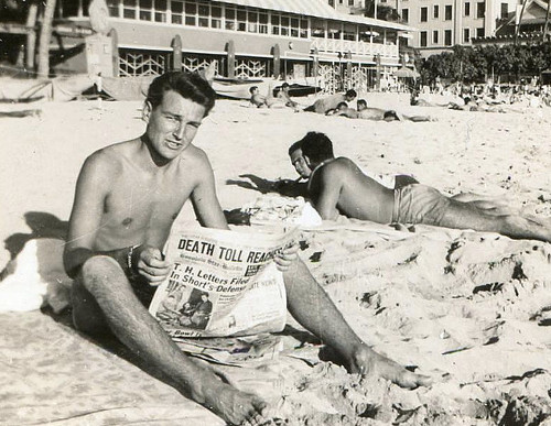 Vintage man reading newspaper at beach.