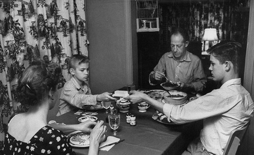 vintage family eating at dinner table brother passing dish to brother 