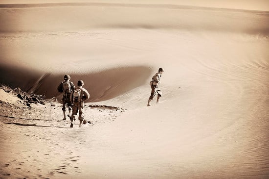 Military soldiers hiking in desert. 