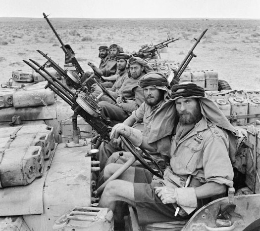 Vintage military soldiers with guns in desert trucks. 