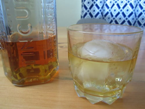 whiskey in glass with large ice ball