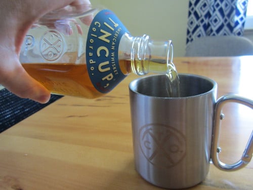 pouring tincup whiskey into tin cup