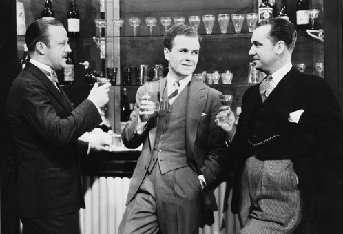 Vintage men drinking cocktails at bar.