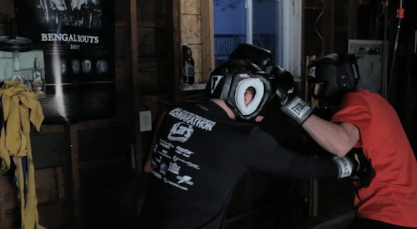 Two men fighting sparring in garage home fight club.