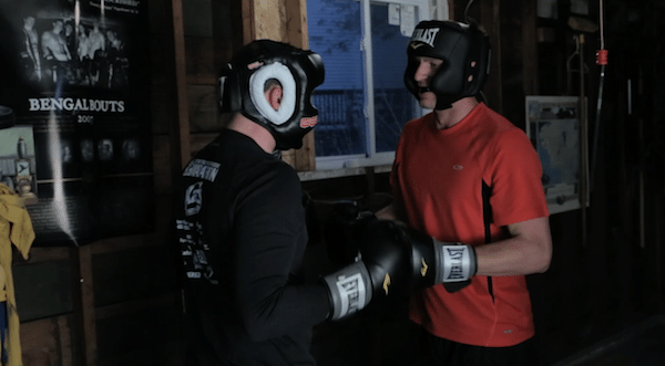 Two men fighting sparring in garage home fight club.