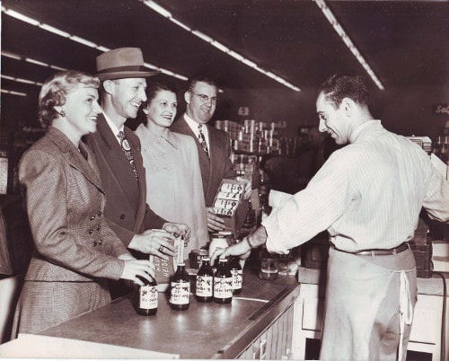 Vintage people at grocery store checking out small talk with cashier.