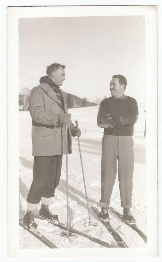 Vintage men on skis talking smiling small talk.