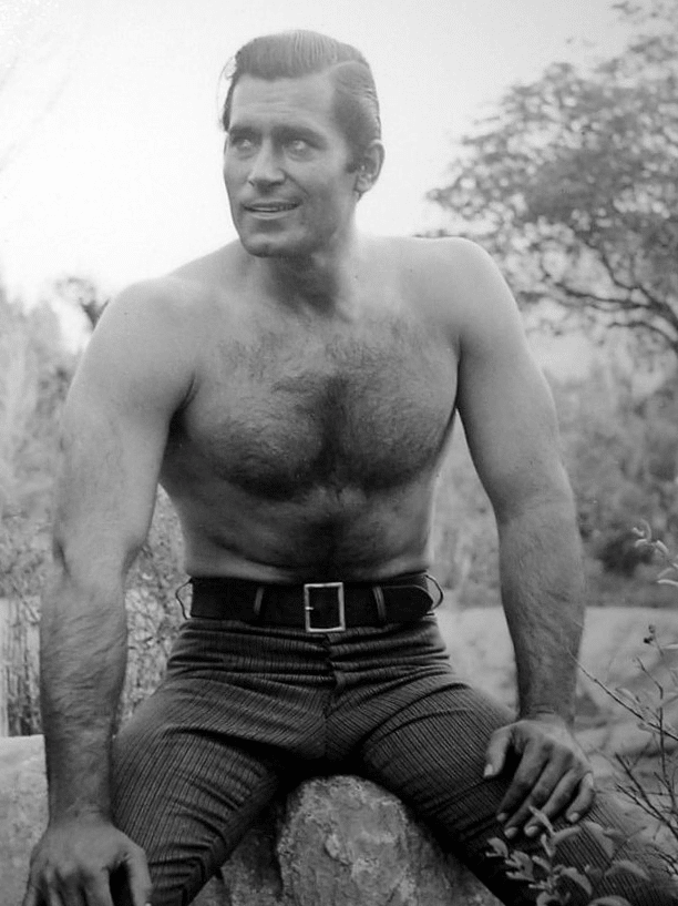 Vintage shirtless man in dress pants with smile hairy chest.