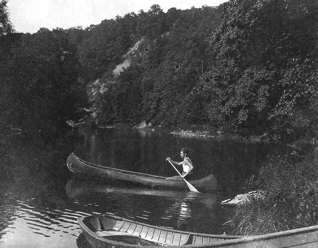 Vintage man rowing boat in wilds. 