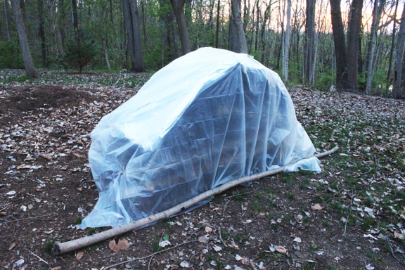 A complete view of survival shelter bed in forest.