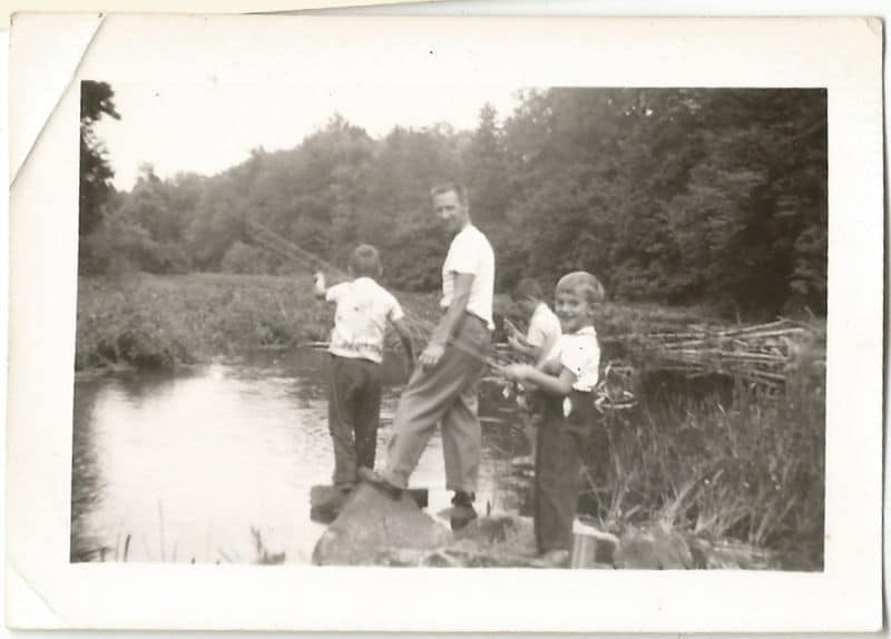 Vintage father and sons fishing in pond. 