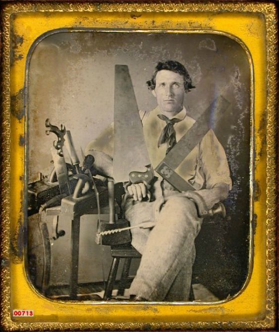 Vintage man sitting portrait with saws Hand tools.