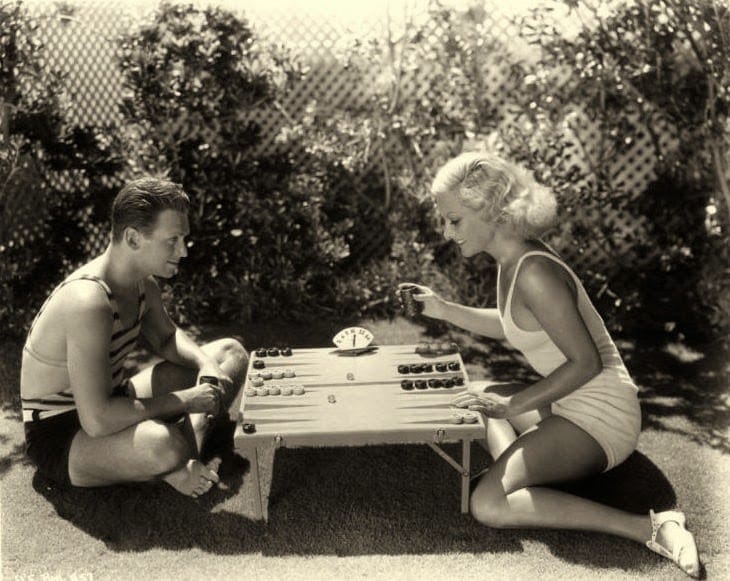 Vintage couple playing backgammon on short Table. 