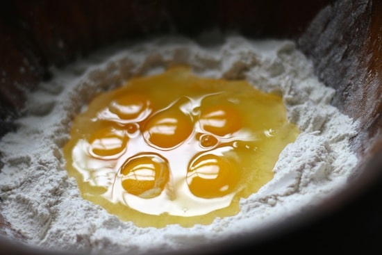 cracked eggs in center of flour well