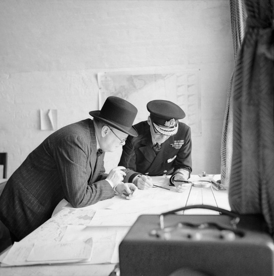 Winston Churchill looking at war map with general. 