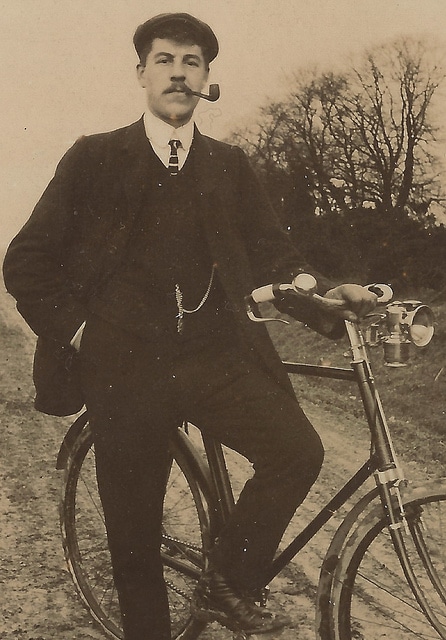 Vintage man on bicycle smoking pipe. 