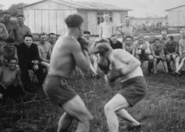 Vintage men fighting boxing in field. 