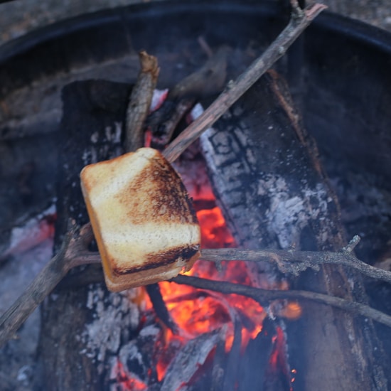 grilled cheese cooking on stick over fire