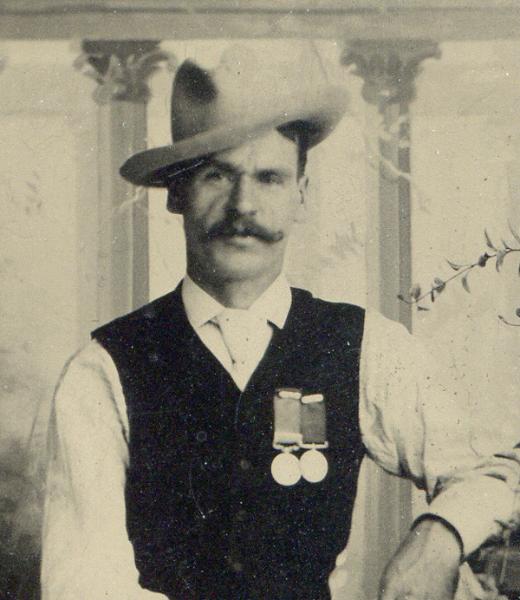 A man with hat and mustache on face. 