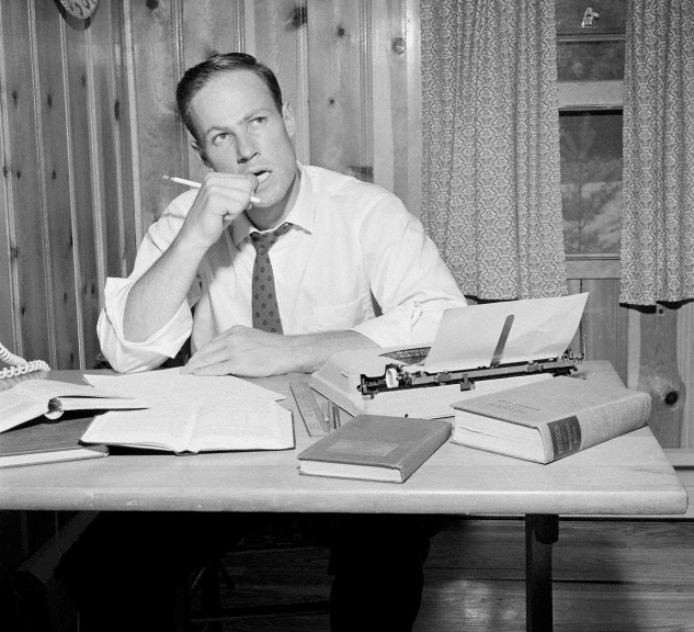 A thinking man sitting on a desk. 