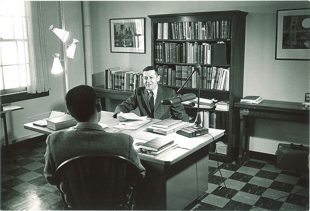 Men are discussing in Professor office.