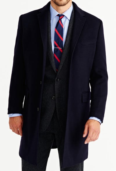 Man wearing overcoat, over suit and tie.
