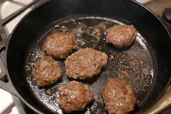 Cooked sausage patties in skillet.