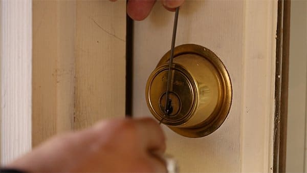 Close up picking a lock pin tumbler deadbolt.