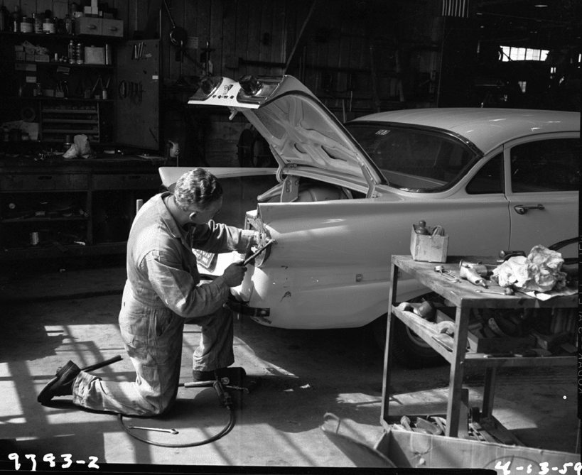 Vintage mechanic working on car.