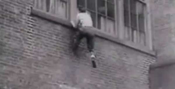 Vintage man scaling climbing brick wall parkour.