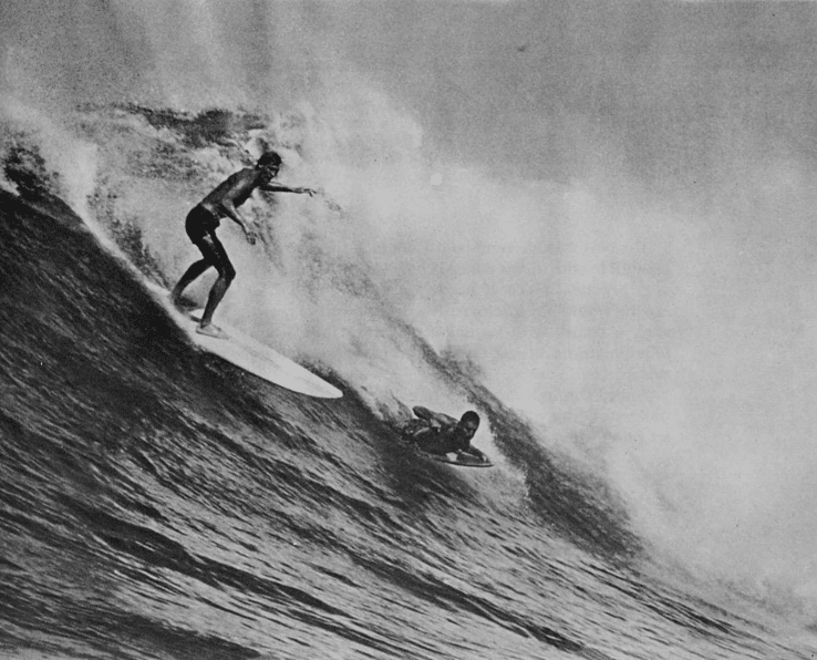 Vintage surfers riding big waves standing.